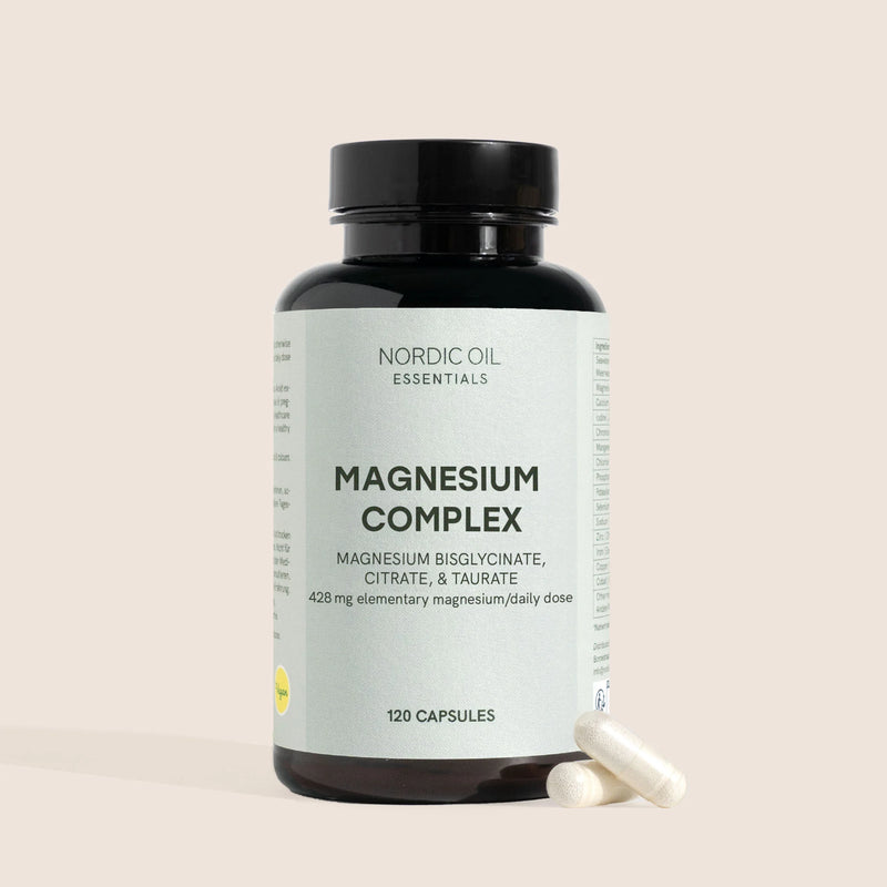 Nordic Oil Essentials Magnesium Complex-flaske med to kapsler ved siden af