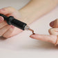 Pipette drypper olie ned på en finger