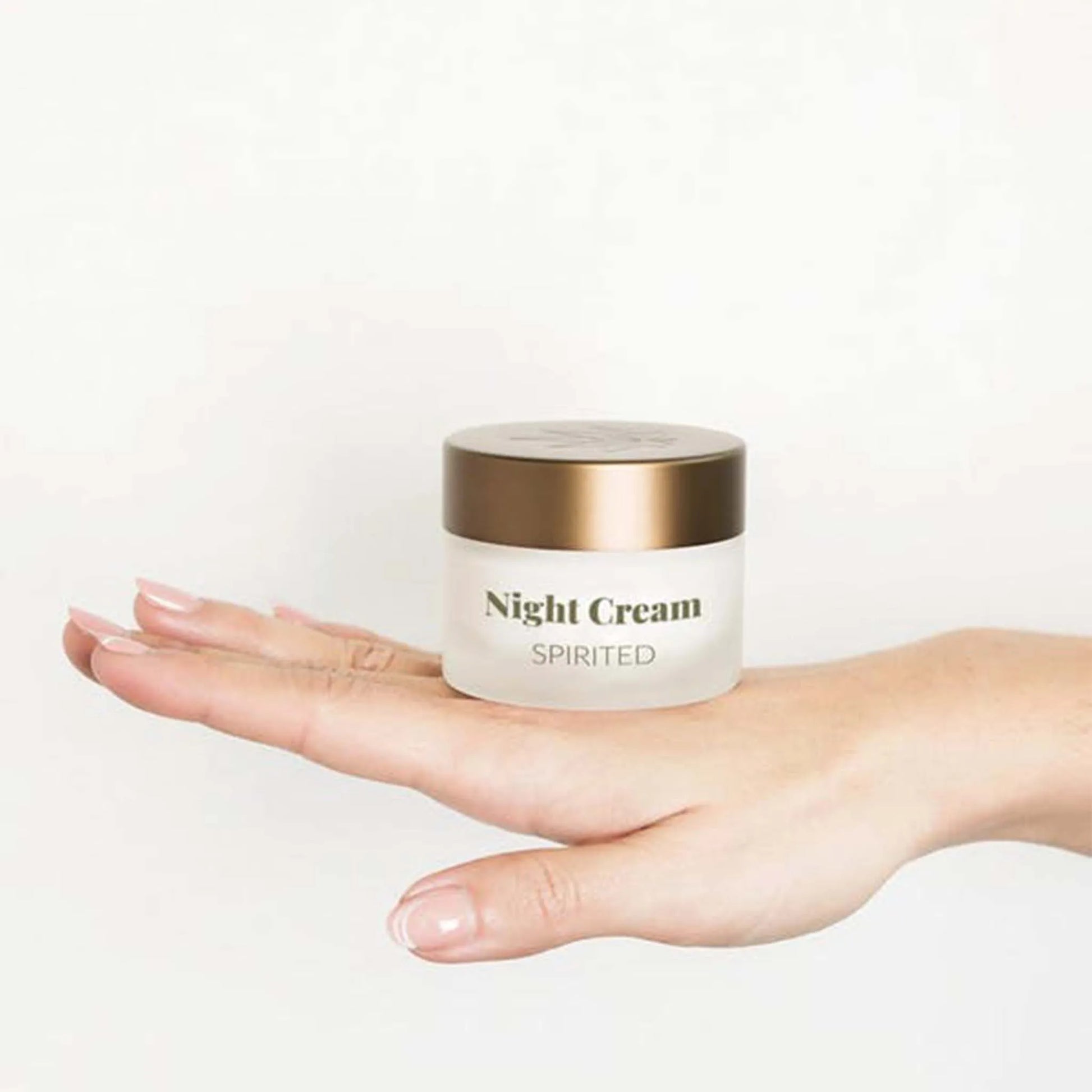 Æsken med CBD Natcreme + E Vitamin ligger på bagsiden af ​​en kvindes hånd.