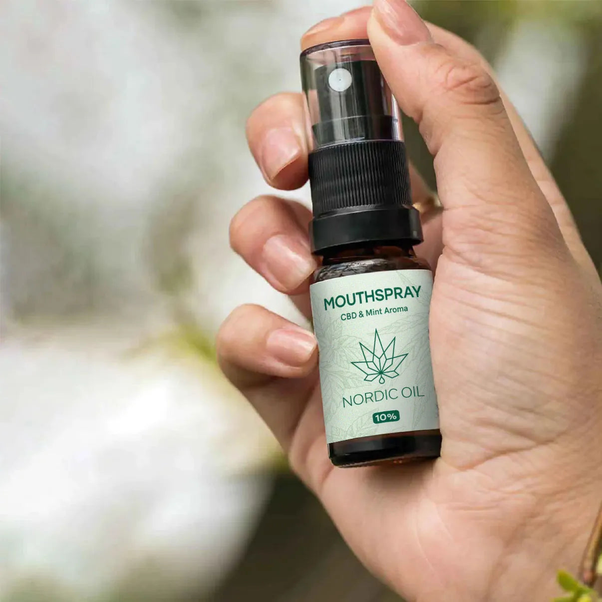 Mundspray med CBD og myntearoma fra Nordic Oil, holdt i en hånd