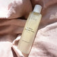 Nordic Cosmetics 2-fase rensevand Gentle med CBD og jojobaolie på lyserødt stof