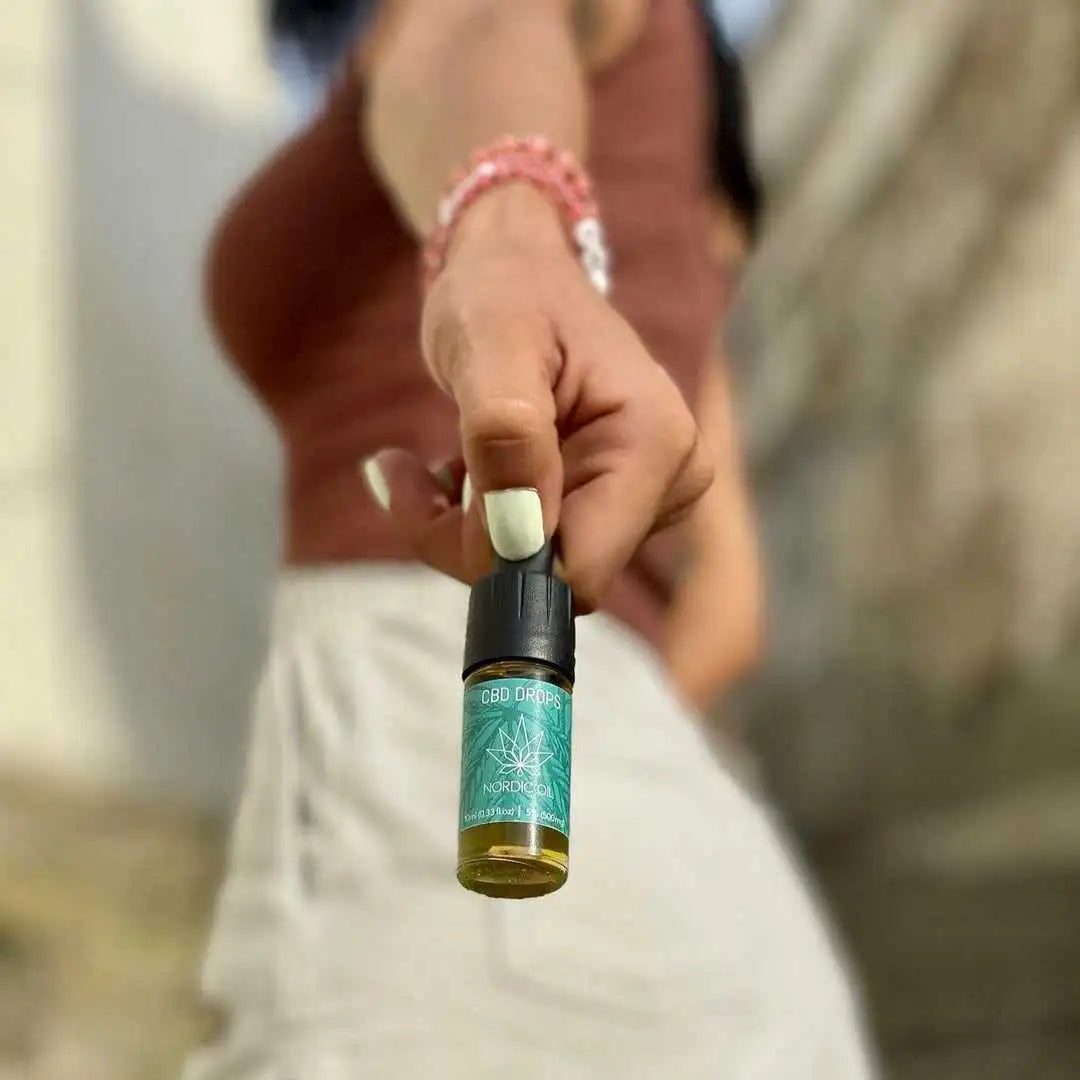 CBD-dråber flaske fra Nordic Oil holdes op af en hånd
