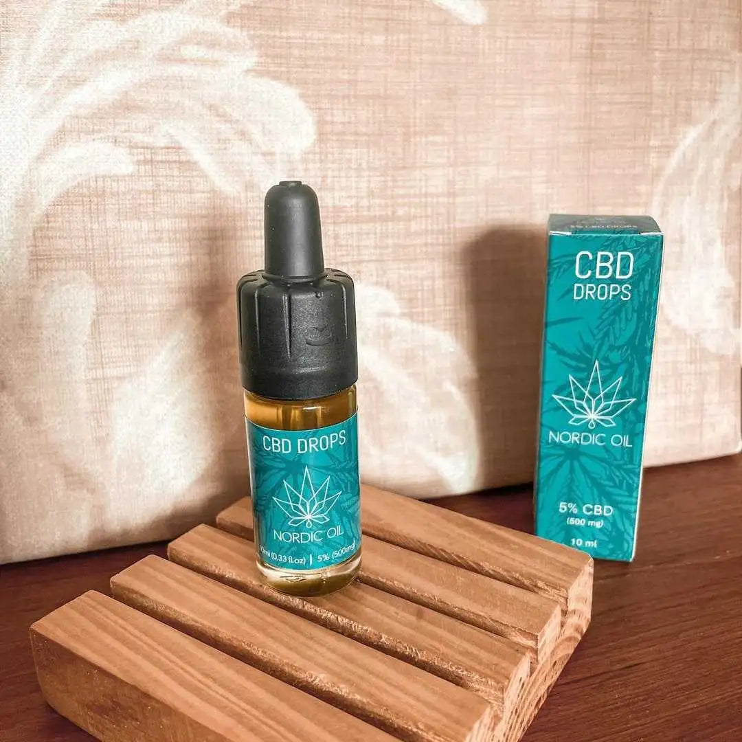 CBD-drops flaske og æske fra Nordic Oil med 5% CBD på træoverflade