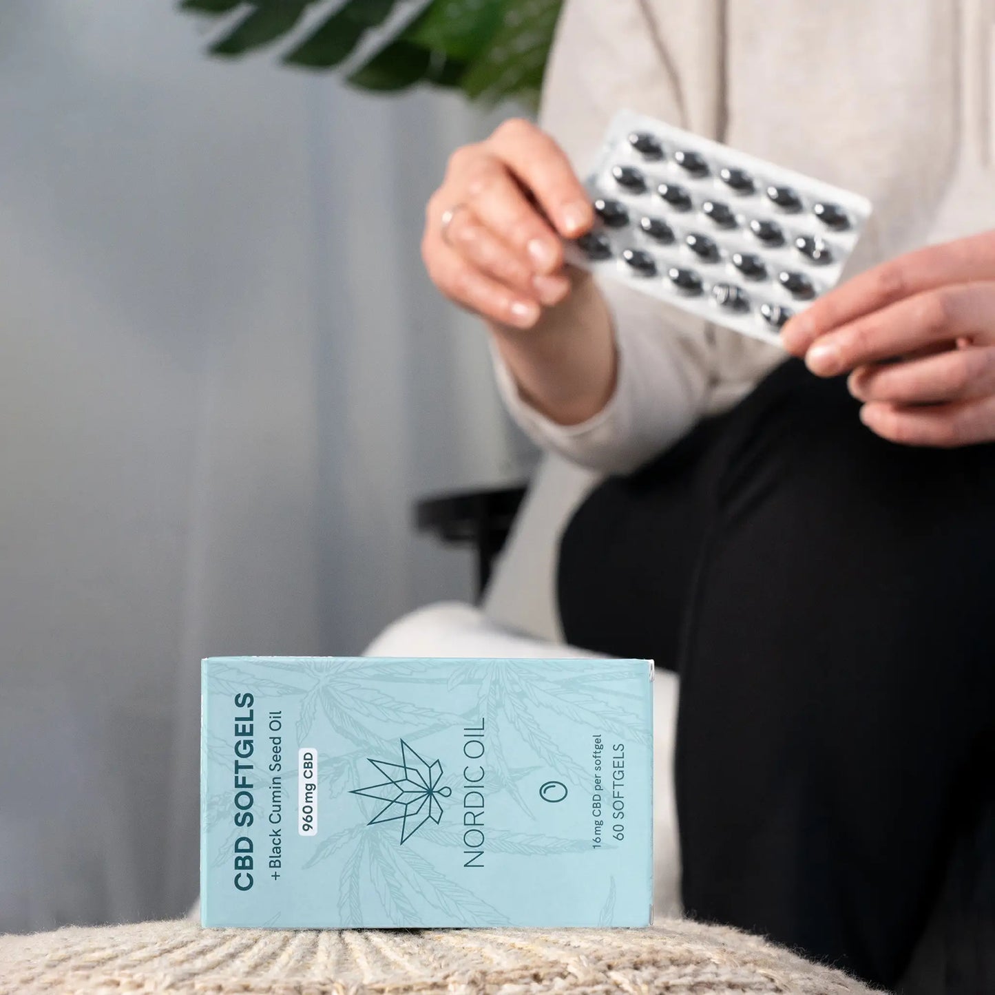 Nordic Oil CBD Softgels-æske foran en hånd, der holder en blisterpakning.