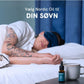 Sovende person i seng med en flaske Nordic Oil søvn-drops og en kop på natbordet.