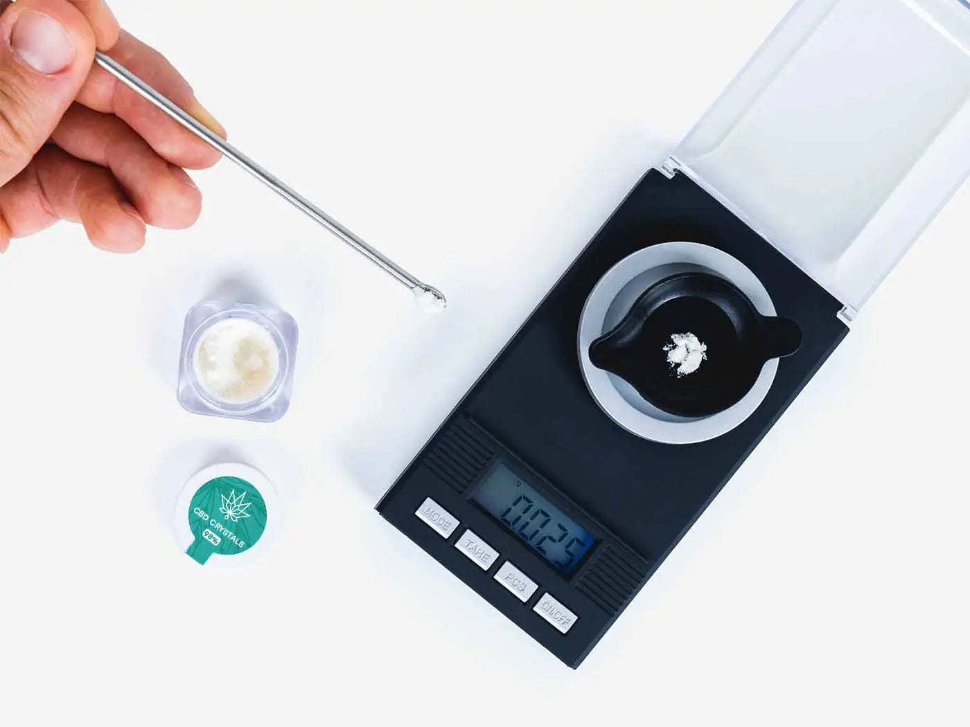 CBD-krystaller målt på en digital vægt med pipette og lille beholder