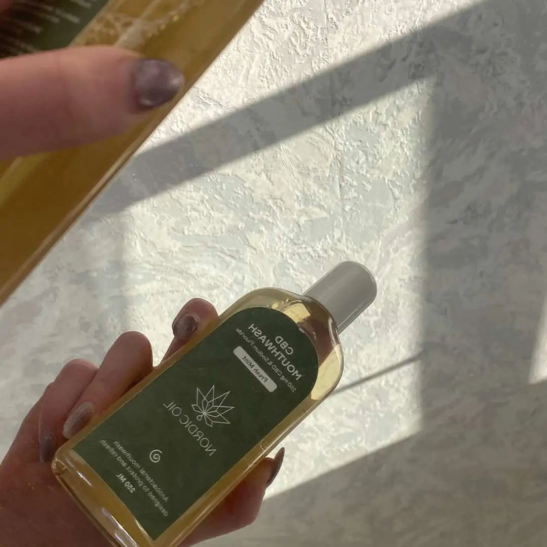 Nordic Oil CBD-olie i glasflaske med dropper, holdes i hånden
