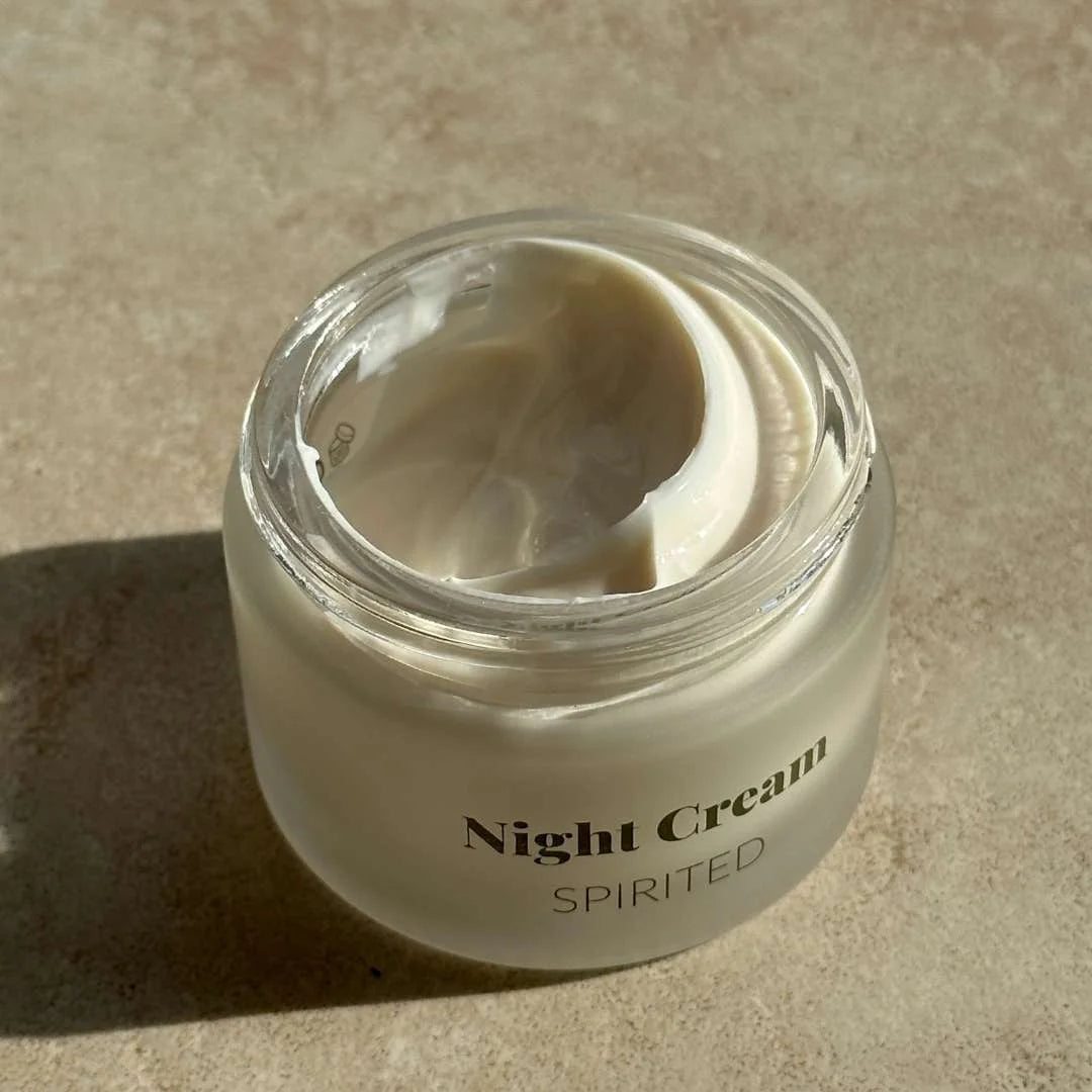Åben glaskrukke med hvid natcreme