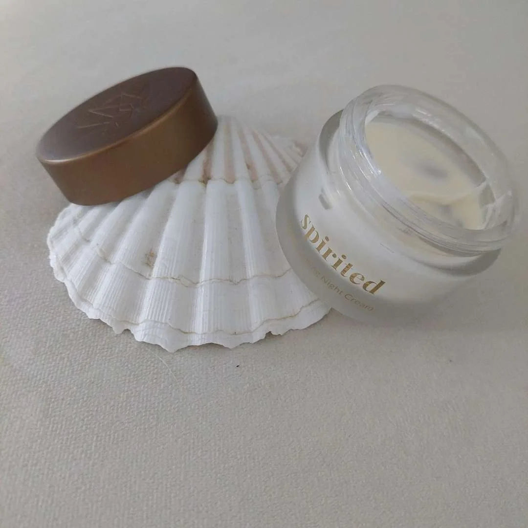 Spoiled natcreme i glasbeholder ved siden af en hvid muslingeskal