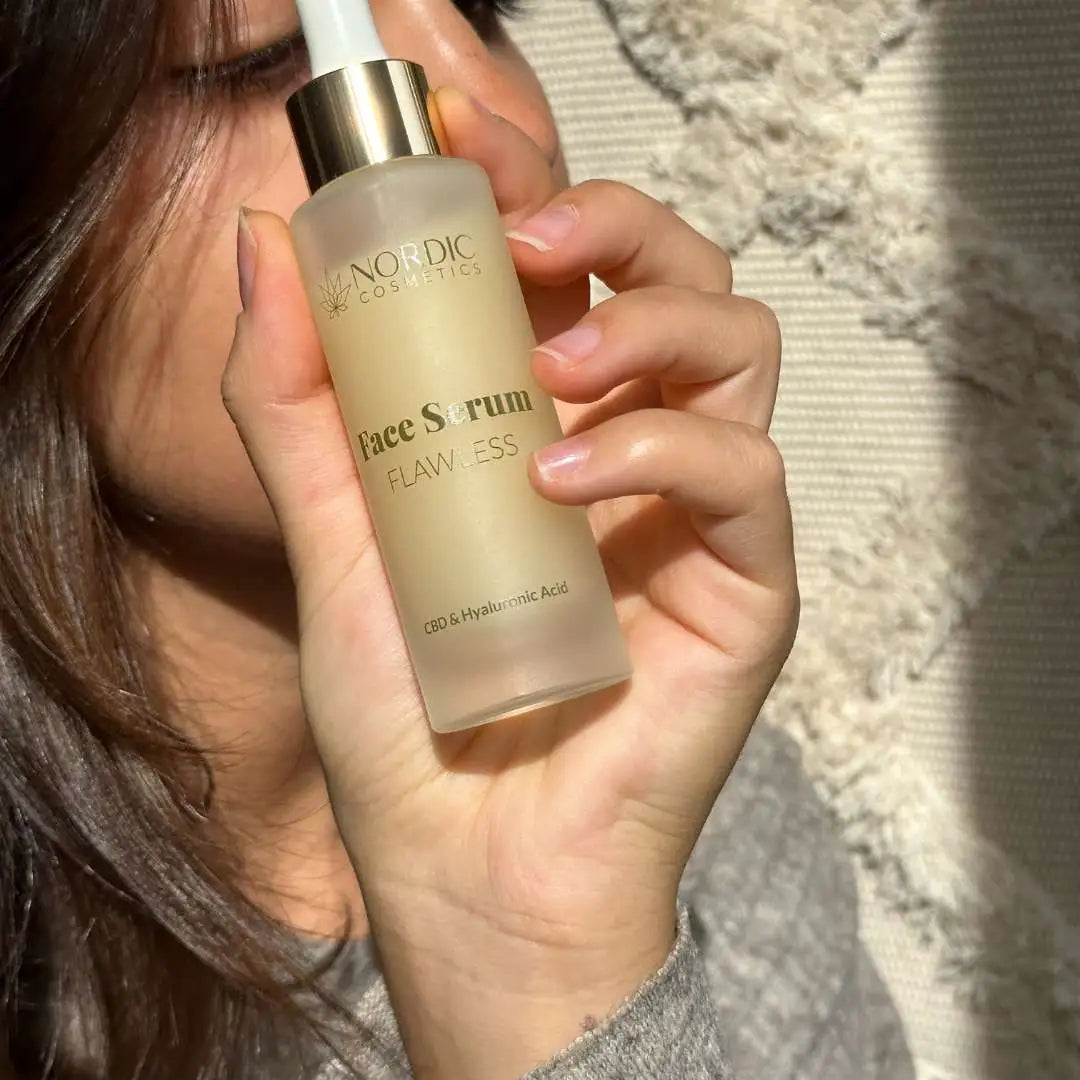 Person holder en flaske ansigtsserum fra Nordic Cosmetics med CBD og hyaluronsyre.