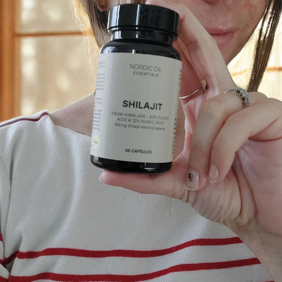 Flaske med Nordic Oil Shilajit-kapsler (60 kapsler) holdes af en person.