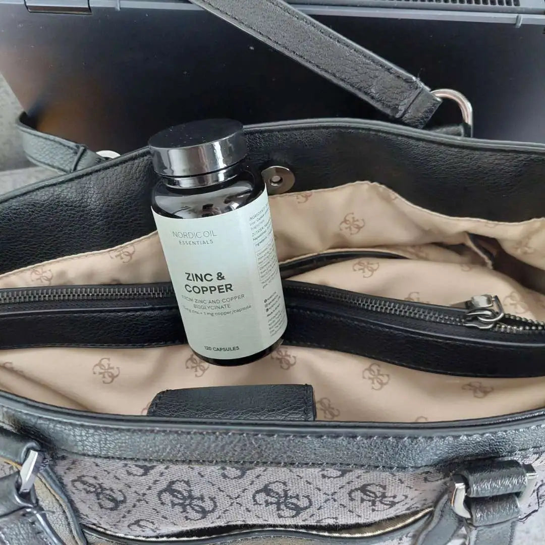 Nordic Oil Essentials Zink og kobber kosttilskud i en sort håndtaske.
