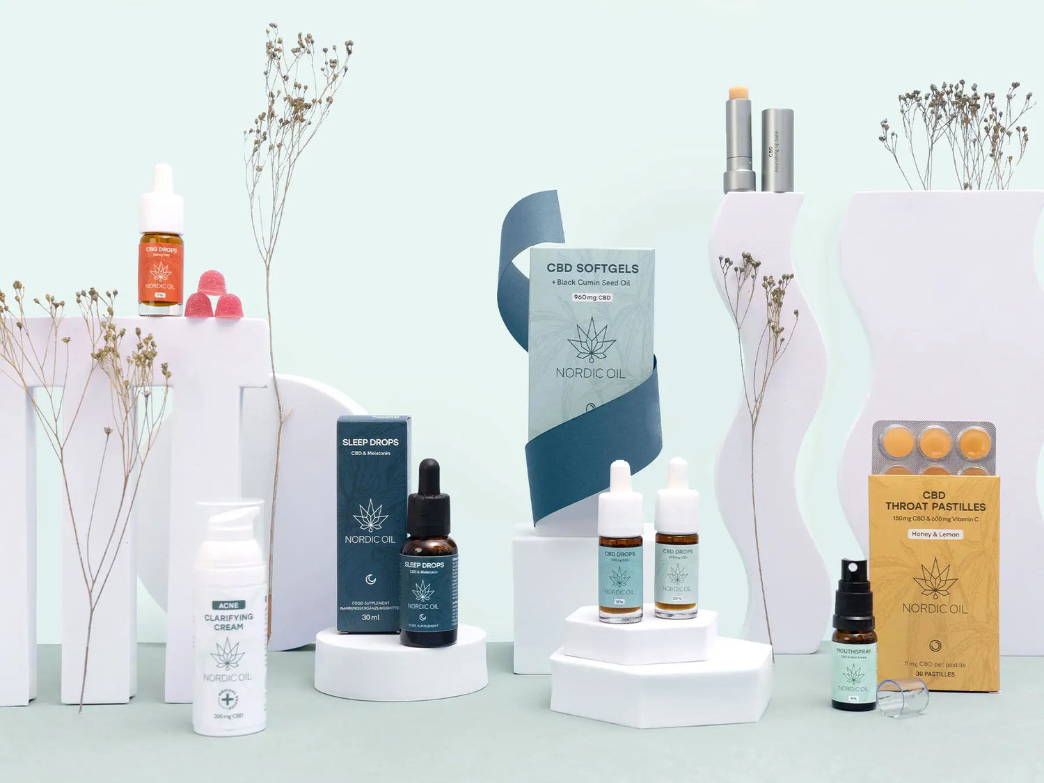 Nordic Oil CBD-produkter og kosttilskud arrangeret i pastelfarvet scenografi.