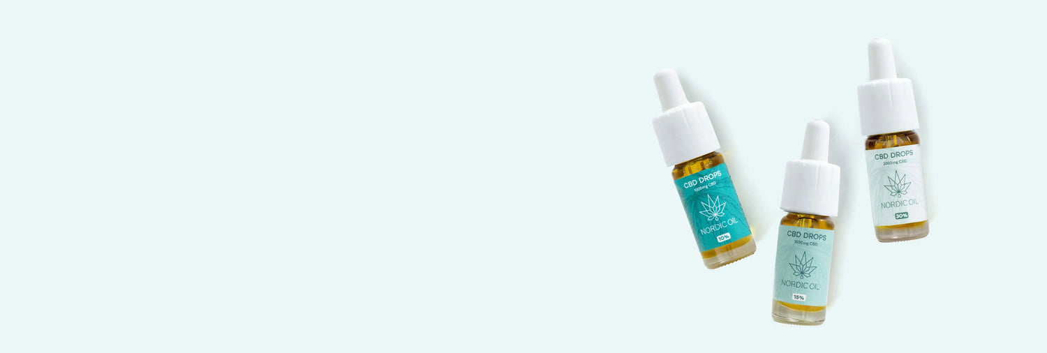Tre CBD Drops-flasker ligger på et hvidt gulv.