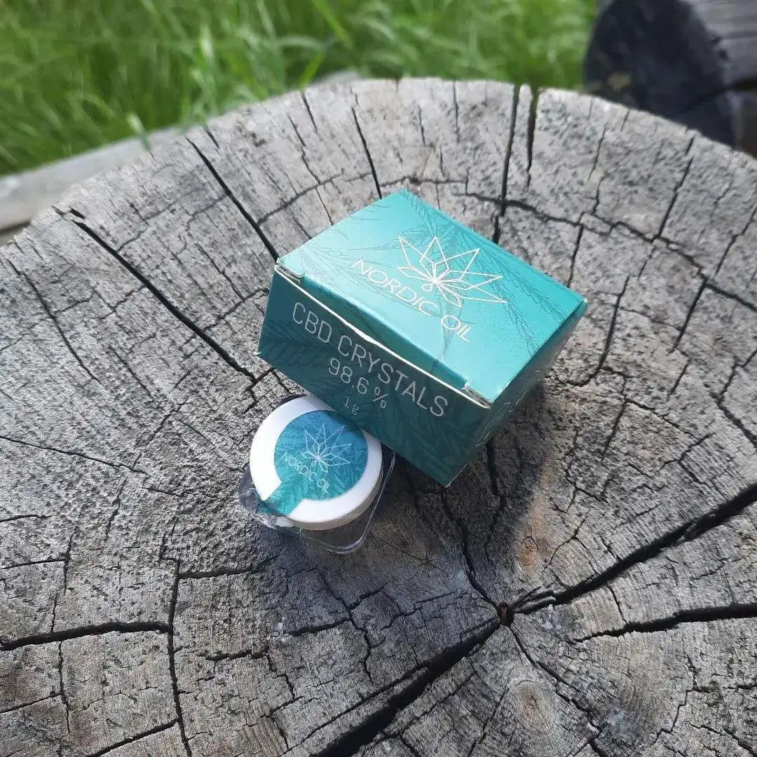 Nordic Oil CBD Crystals-æske og lille beholder på en træstub