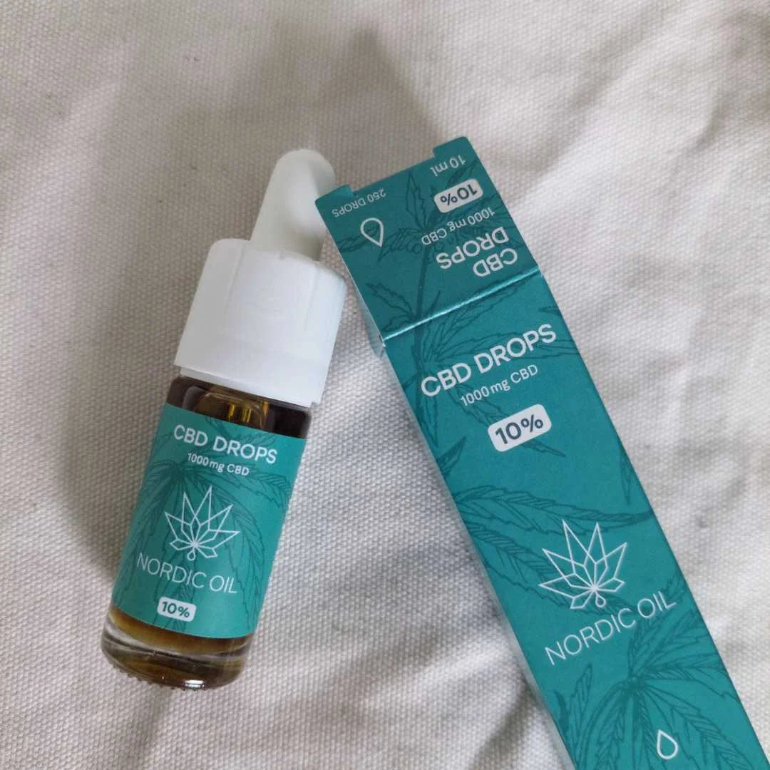 Nordic Oil CBD Drops – 1000 mg CBD, glasflaske med dropper ved siden af teal emballage