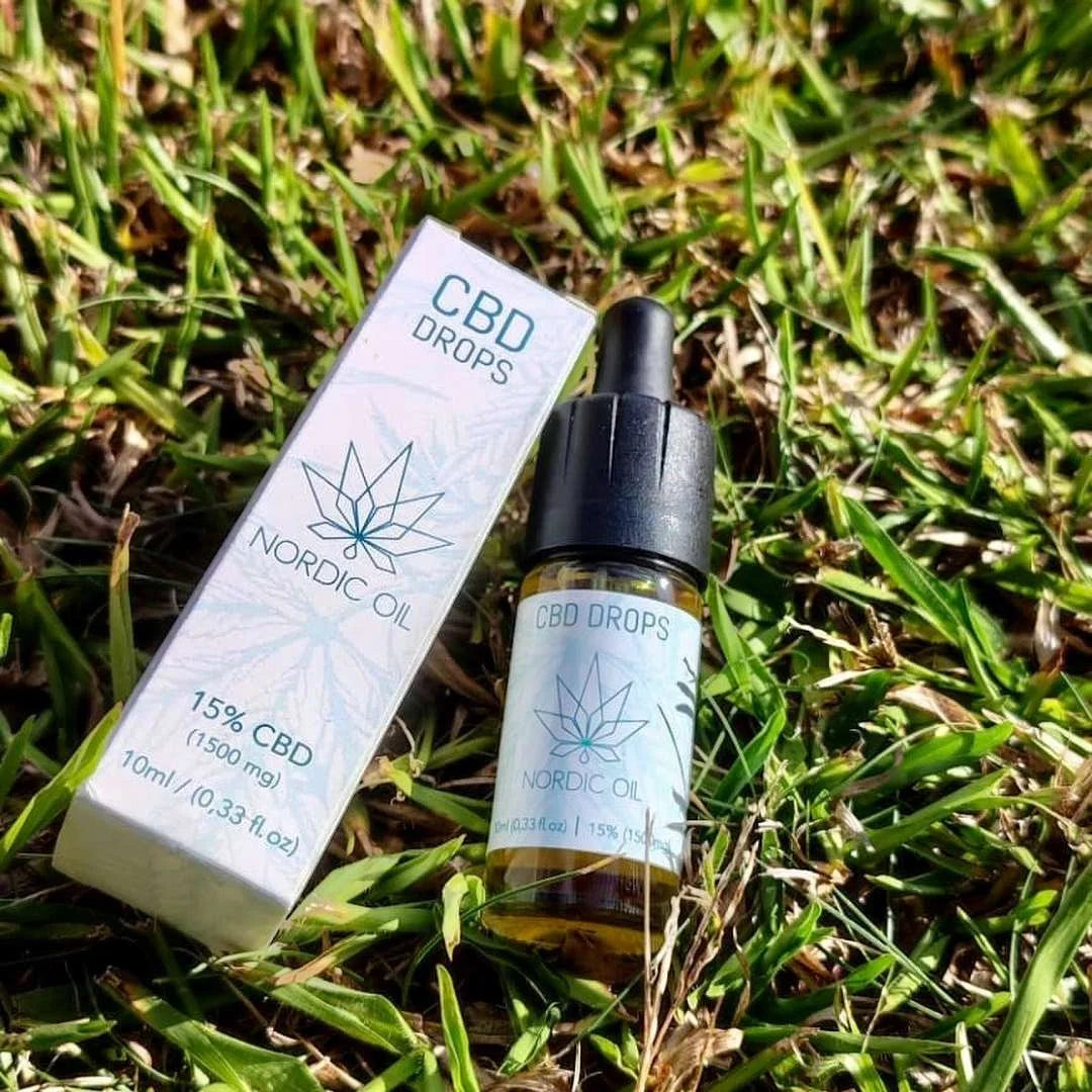 Nordic Oil CBD Drops æske og dropperflaske liggende i græs