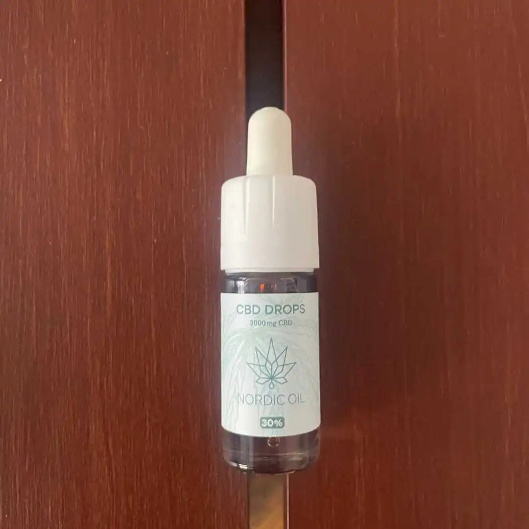 CBD-dråber flaske med pipette og Nordic Oil-mærke på træbord