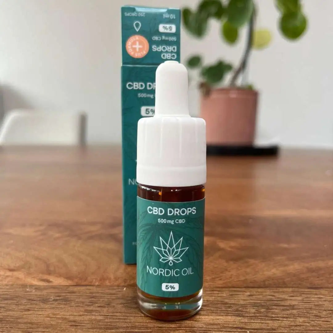 Nordic Oil CBD-drops i grøn emballage med dropper på træbord