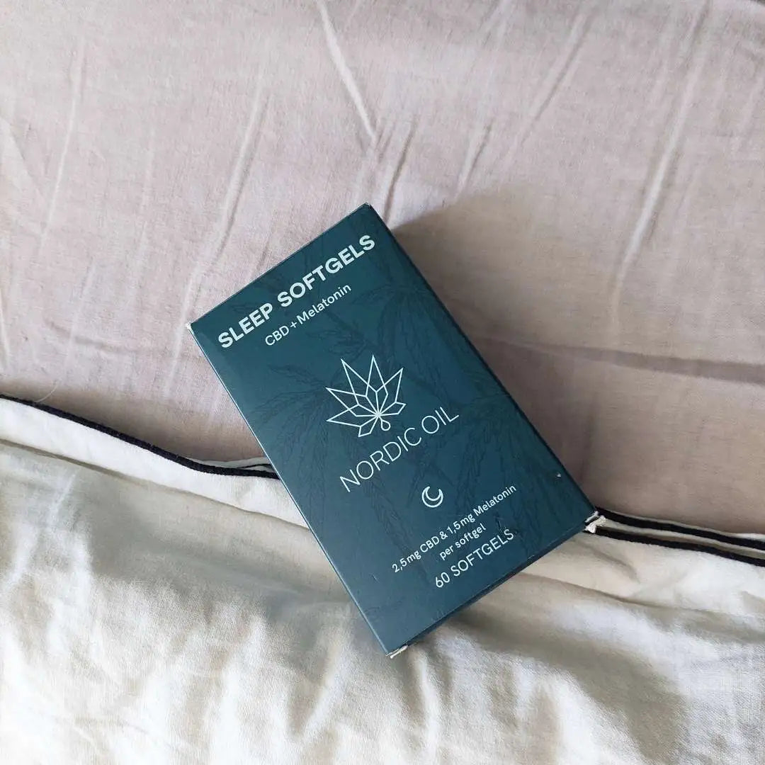 Nordic Oil Sleep Softgels-boks med CBD og melatonin liggende på sengetøj