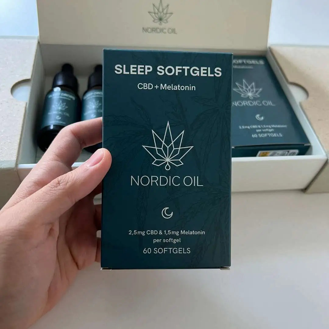 Hånd holder blå Nordic Oil Sleep Softgels-æske med CBD og melatonin