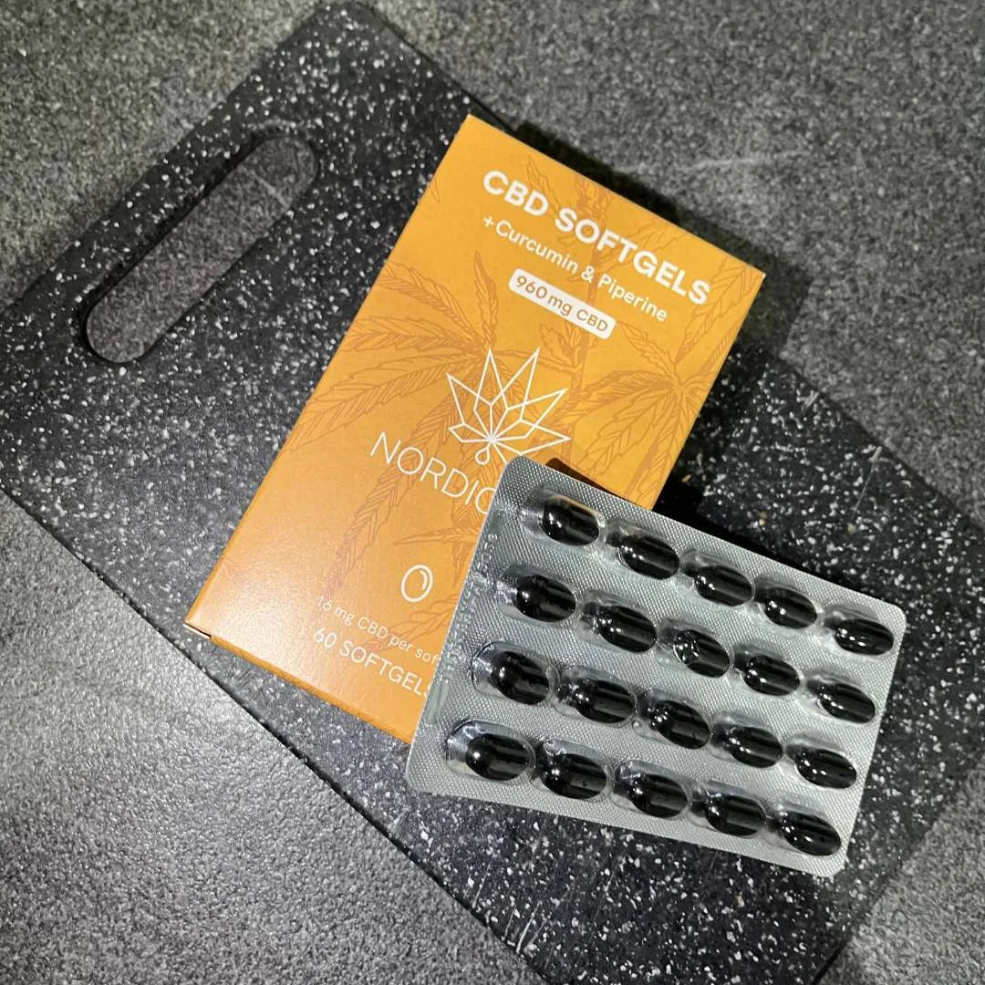 CBD-softgelkapsler i blisterpakning ved siden af en orange Nordic Oil-æske med kurkumin og piperin.