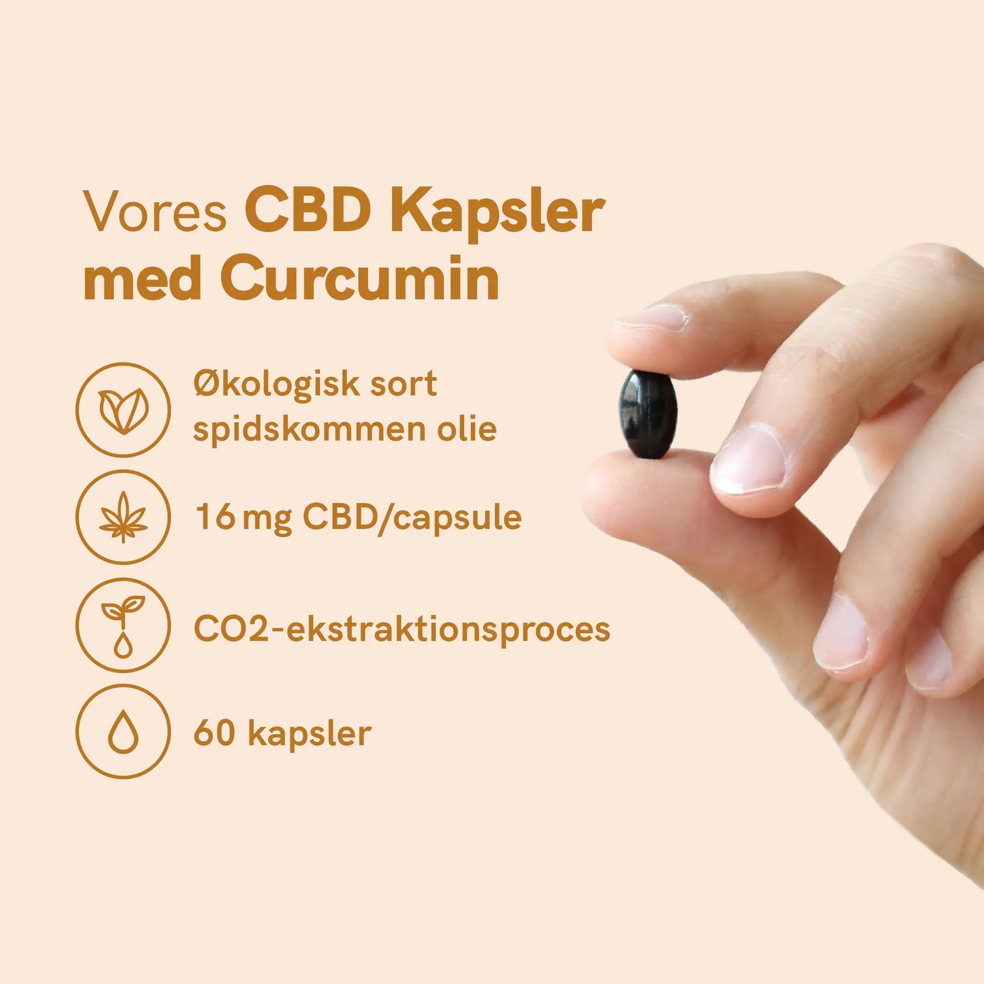 CBD-kapsler med curcumin – hånd der holder en sort kapsel.