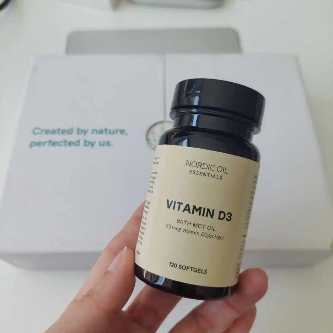 Nordic Oil Essentials Vitamin D3 softgel-flaske holdes i hånden