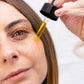 Nærbillede af en person, der drypper CBD-olie ved øjet med en dropper.