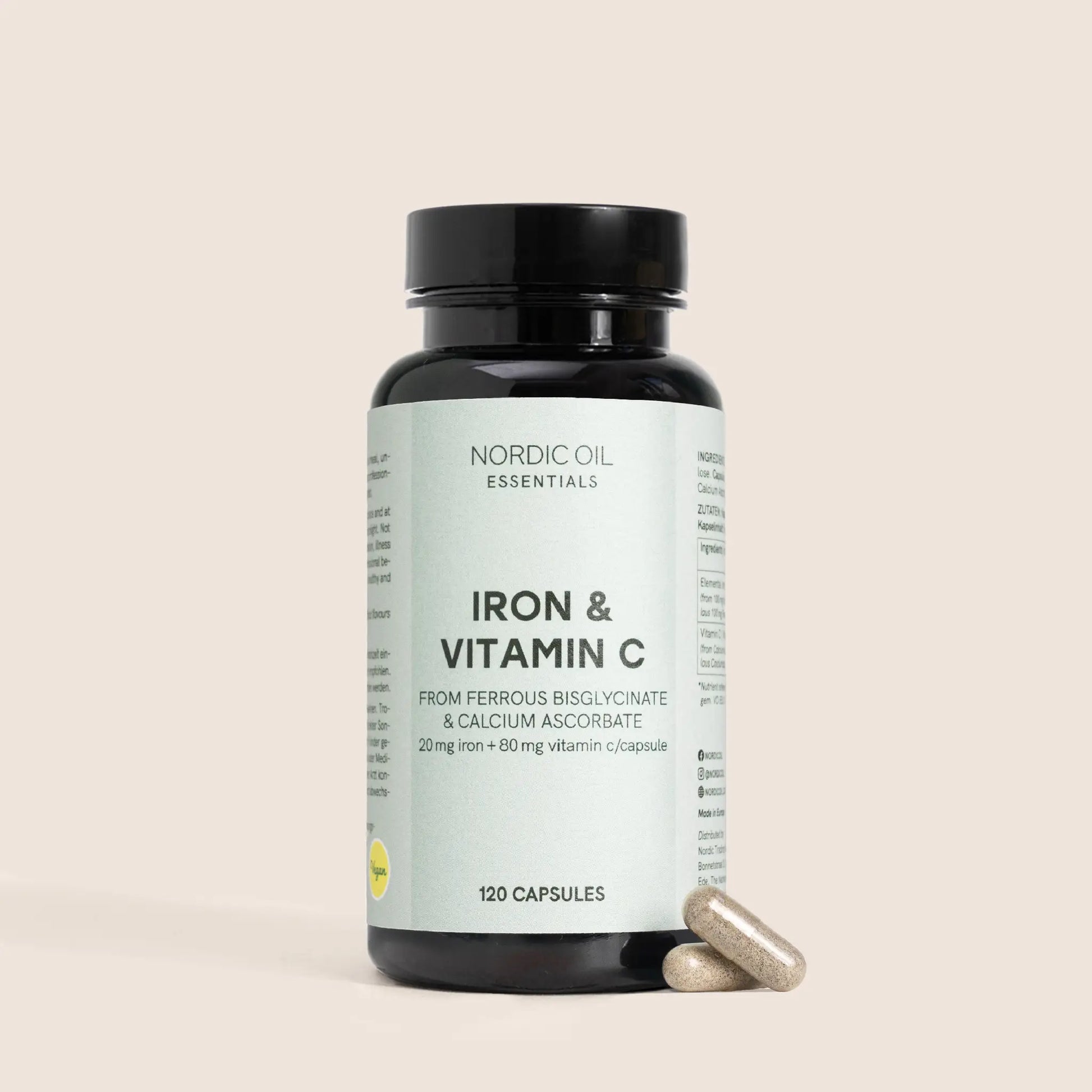 Nordic Oil Essentials jern og C-vitamin-kapsler i flaske med to kapsler ved siden af