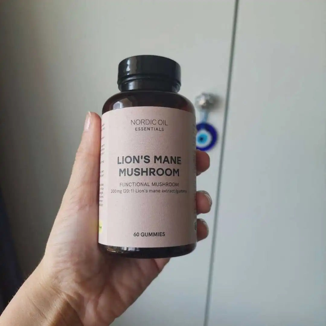 Hånd holder flaske med Nordic Oil Essentials Lion’s Mane Mushroom – funktionelt svampekosttilskud, 60 gummies