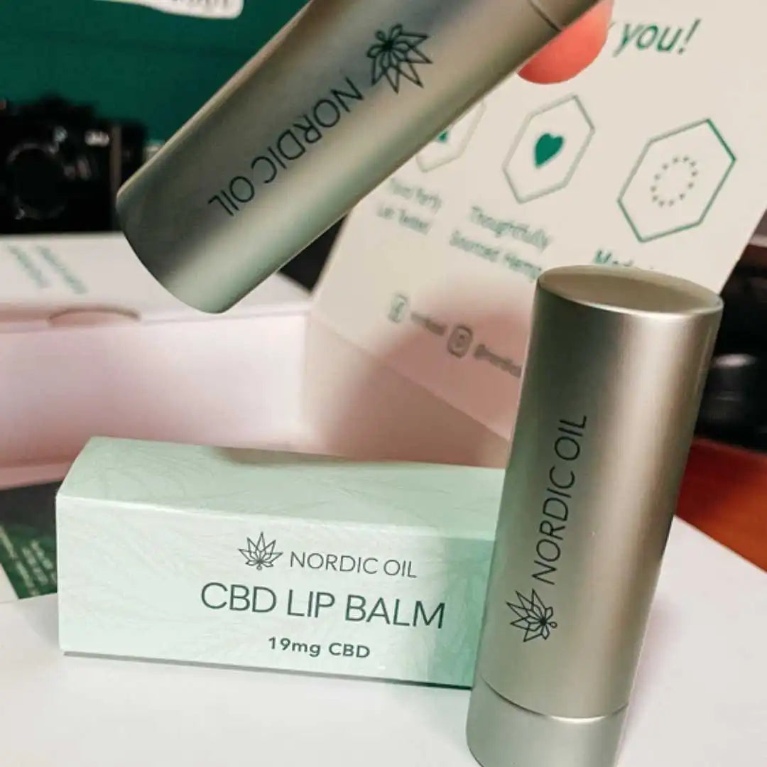 Nordic Oil CBD Lip Balm i sølvfarvet tube ved mintgrøn æske, 19 mg CBD