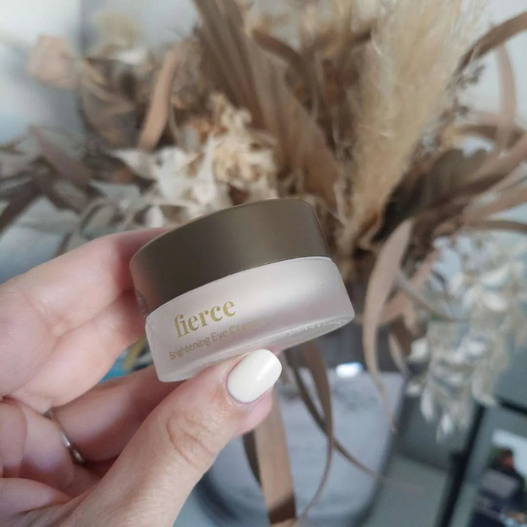fierce Brightening Eye Cream i lille gennemsigtig krukke med brunt låg