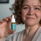 Kvinde holder en lille flaske CBD-olie med pipette mærket Nordic Oil.