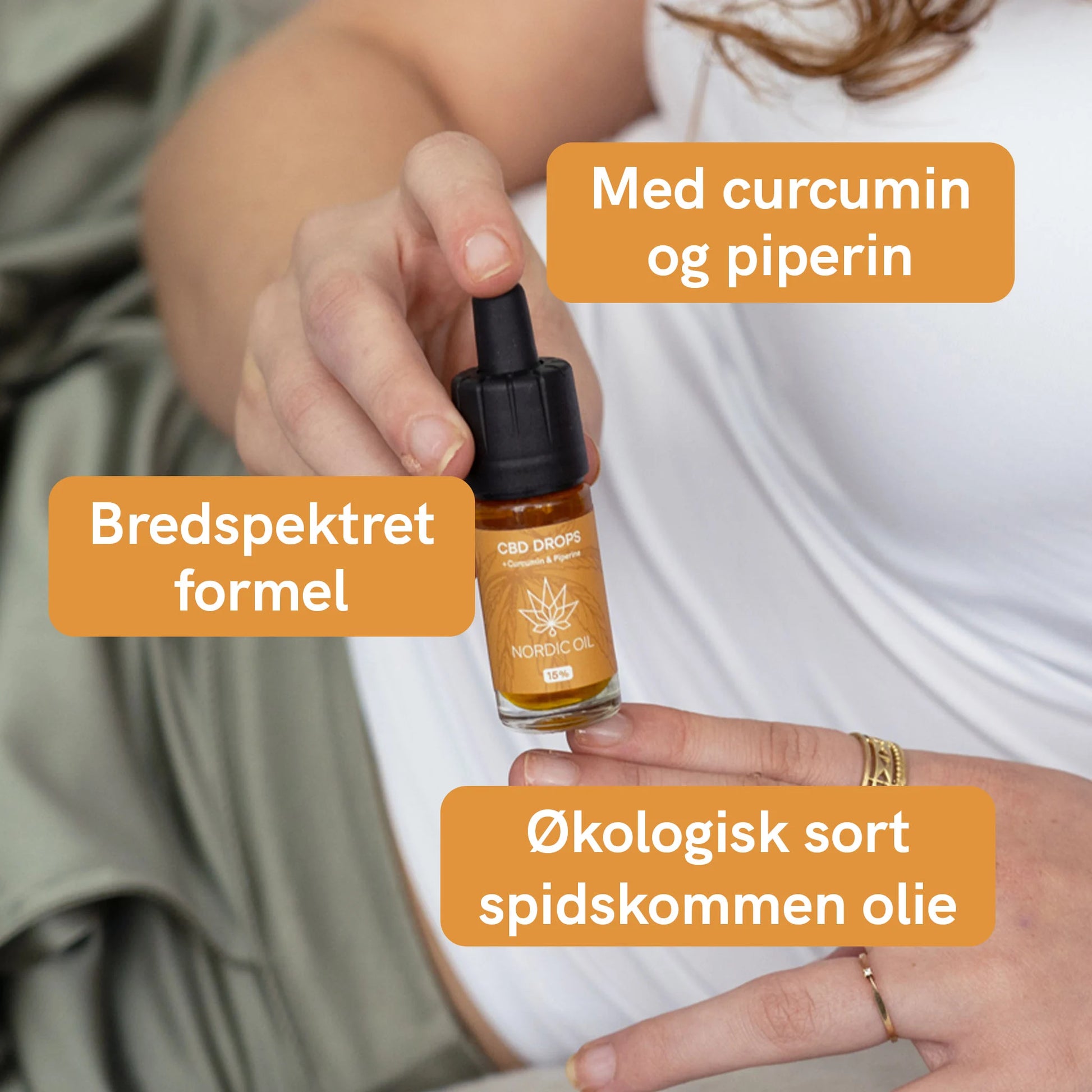 Hånd holder en flaske CBD-olie med dropper fra Nordic Oil, omgivet af orange tekstbokse.