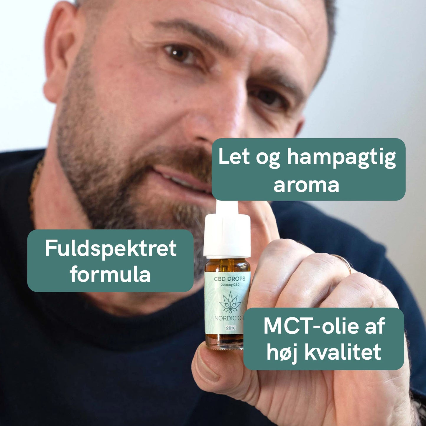 Mand der holder en flaske CBD-dråber fra Nordic Oil.
