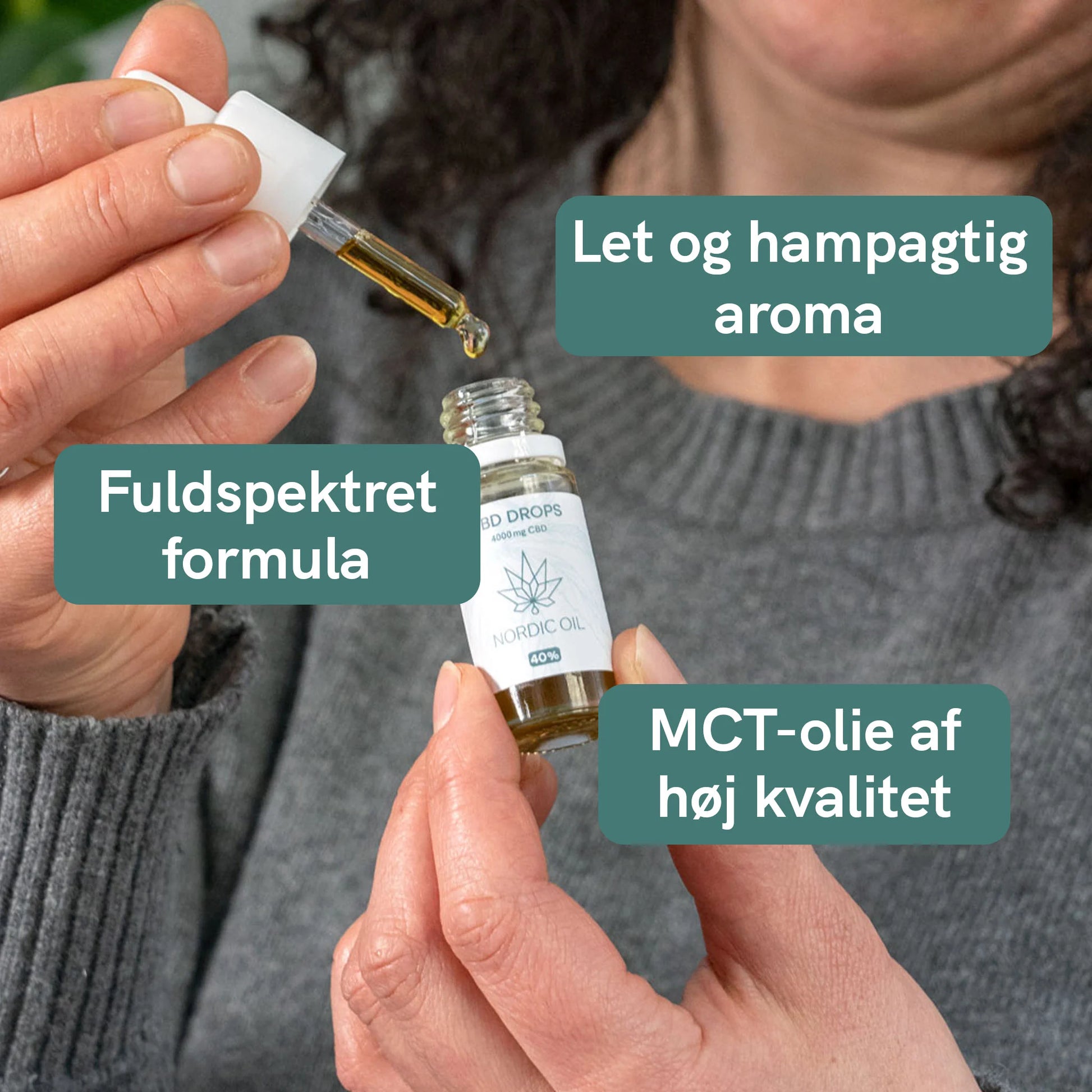 Nærbillede af en person, der hælder CBD-olie fra en dropper ned i en lille flaske mærket Nordic Oil.