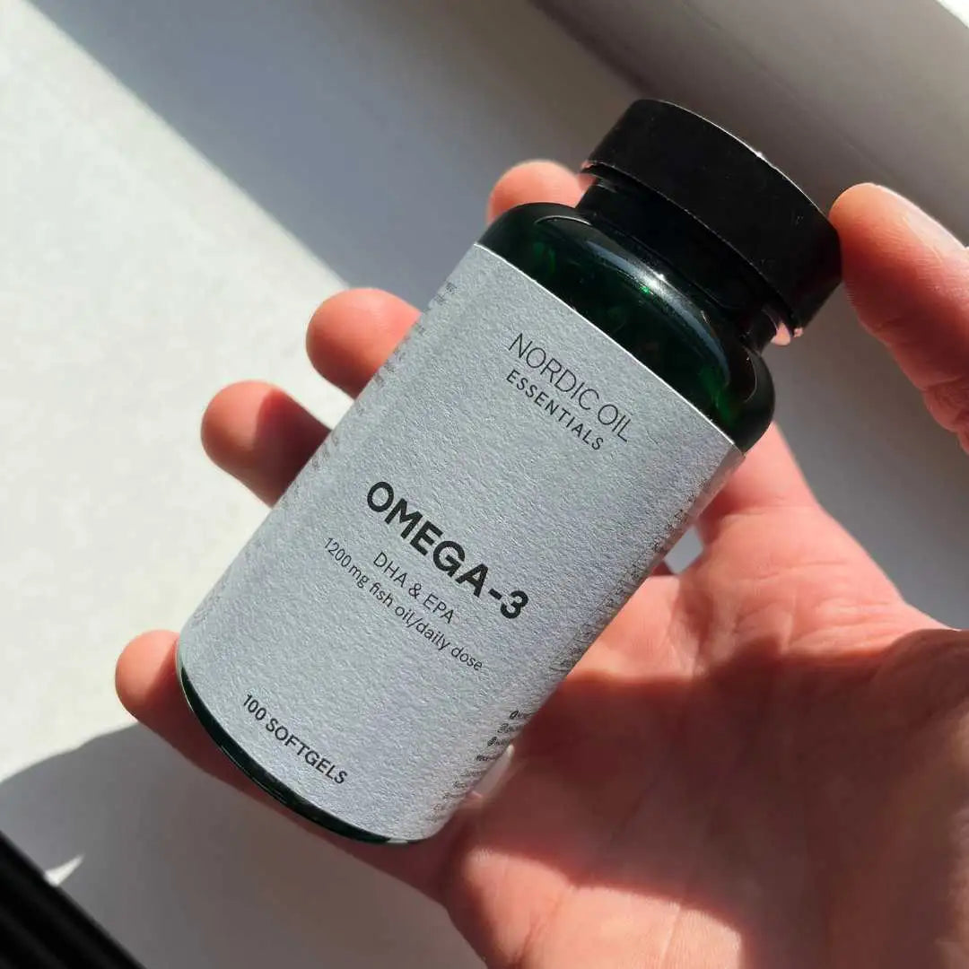 Omega-3 tilskud i grøn glasflaske med sort låg fra Nordic Oil Essentials