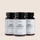 Tre mørkebrune glasflasker med sorte låg og etiketter Nordic Oil Essentials PRE & PROBIOTIC.
