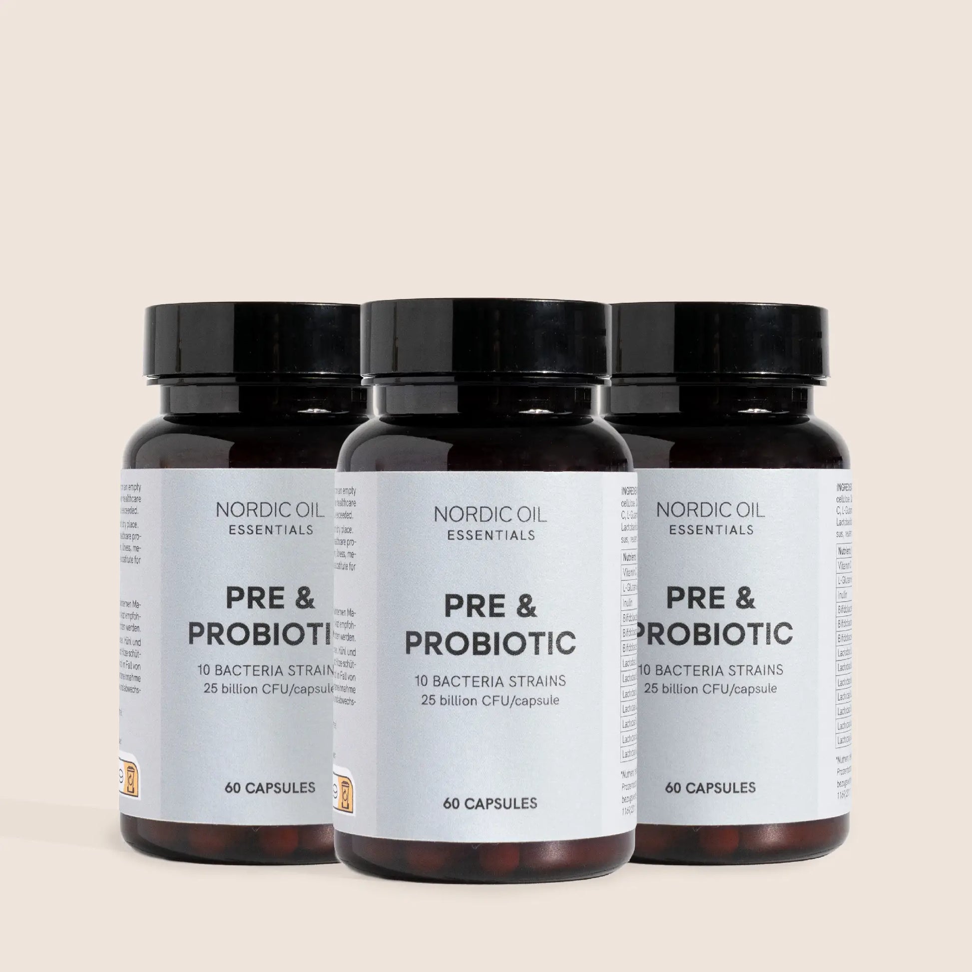 Tre mørkebrune glasflasker med sorte låg og etiketter Nordic Oil Essentials PRE & PROBIOTIC.