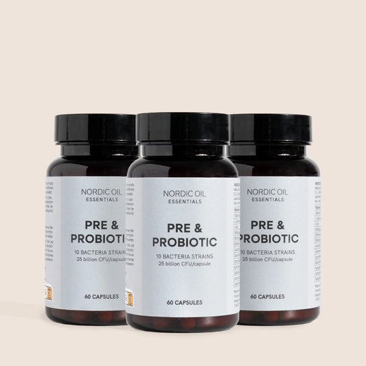 Tre mørkebrune glasflasker med sorte låg og etiketter Nordic Oil Essentials PRE & PROBIOTIC.