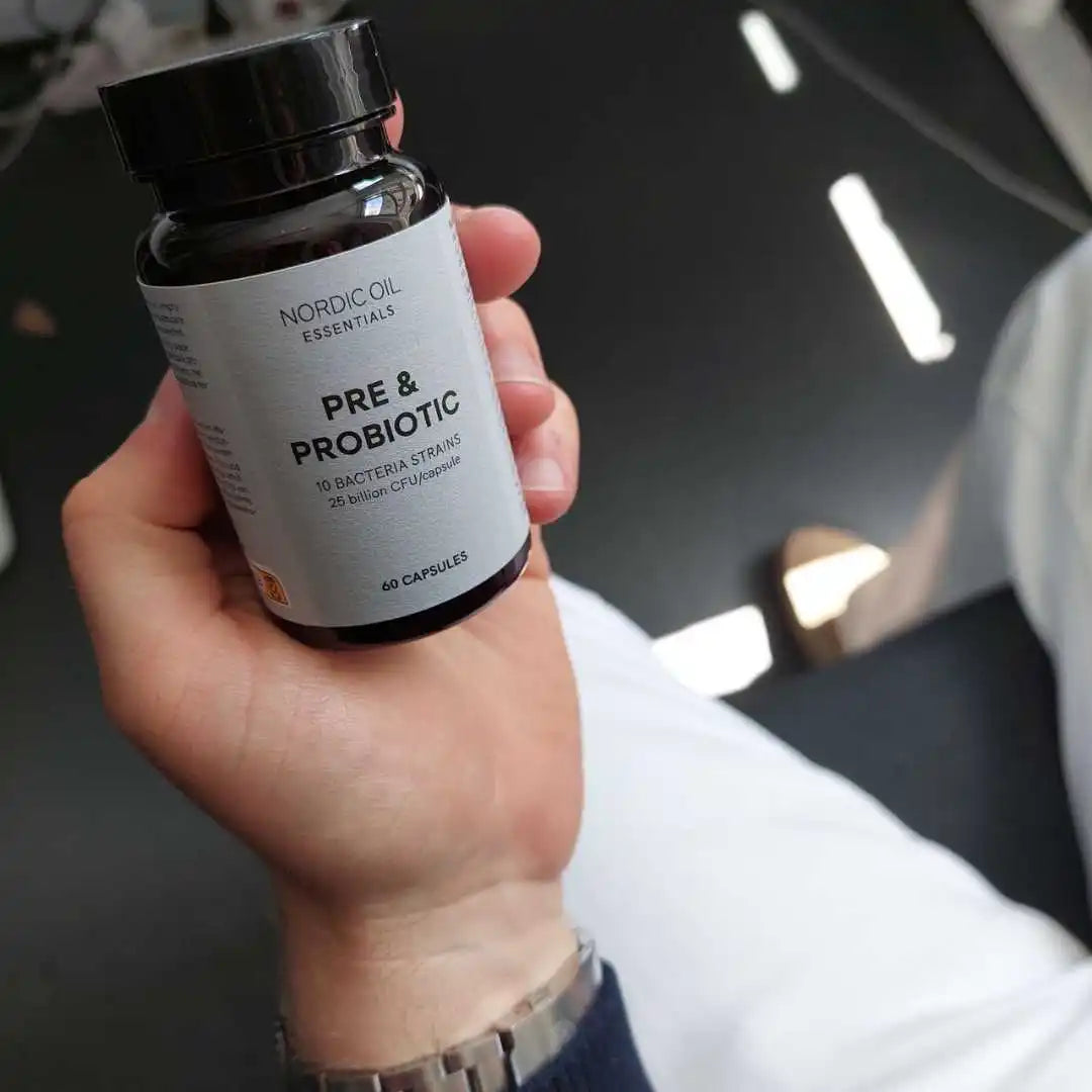 Hånd holder en flaske Nordic Oil Essentials Pre & Probiotic kapsler.