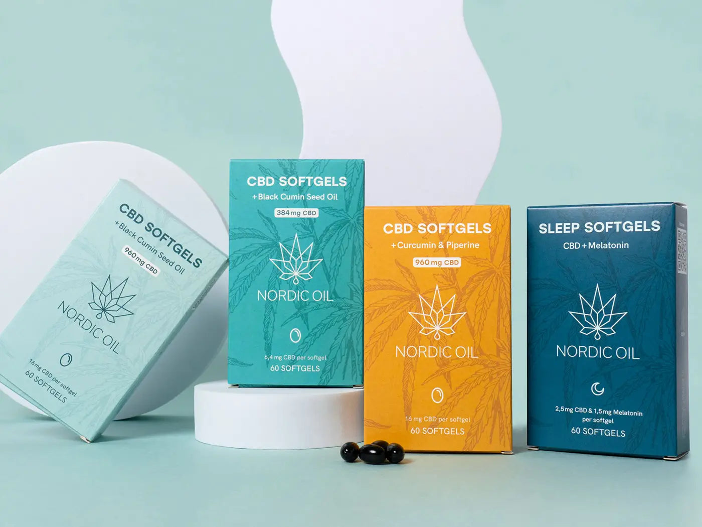 Nordic Oil CBD Softgels emballage i turkis, orange og blå med hampblad-design og små sorte kapsler