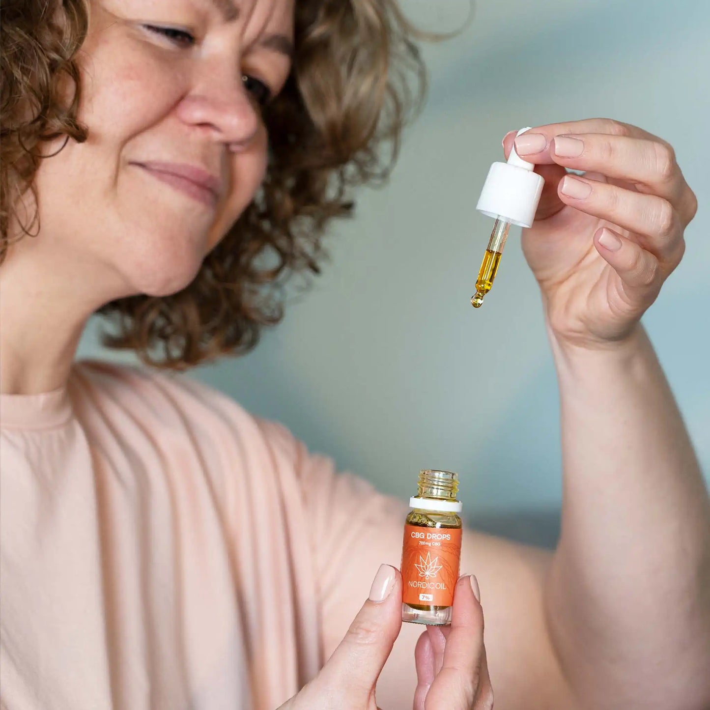 En kvinde bruger pipetten med CBG olie 7% fra Nordic Oil